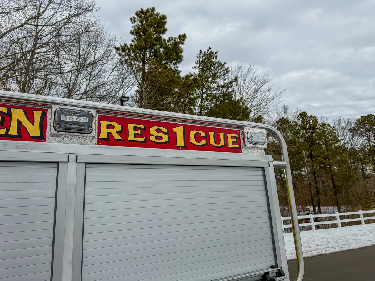 Side panel close-up with BRUSH/RESCUE lettering above roll-up door.